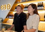 From left, Dave and Lois Cho stand behind the bar in the CHO Wines tasting room, Hillsboro, Ore., Dec. 14, 2024. CHO Wines is the first Korean American-owned winery in Oregon.