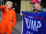 Mike Hisey, left, wearing a mask of former President Trump in a prison uniform while  Mariano Laboy, right, holds a Trump reelection sign outside of Trump Tower on Tuesday, March 21, 2023, in New York.