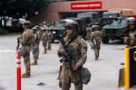 National Guard troops stand outside the Metropolitan Detention Center on Sunday in Los Angeles. Tensions in the city remain high after the Trump administration called in the National Guard against the wishes of city leaders following two days of clashes with police during a series of immigration raids.