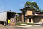 FILE - Moving company workers unload boxes for a clinic in Fargo, N.D., on Aug. 5, 2022.