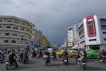 FILE - Motorbikes and cars pass through an intersection in downtown Tehran, Iran, May 17, 2026.