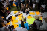 Children scribble on signs in the grass during the Families Belong Together rally in Portland.