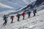 FILE - A group of Indigenous climbers hike Mount Tahoma, also known as Mount Rainier, on June 4.