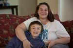 Class Of 2025 student Ethan sits with his mother Melissa in the living room of their Beaverton apartment. The family was homeless for more than two years before finding an apartment in fall 2018.