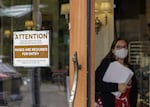 FILE - In this May 21, 2021 file photo, a sign reminds customers to wear their masks at a bakery in Lake Oswego, Ore. As of Wednesday, Aug. 18, 2021, just 41 intensive care unit beds were available in Oregon, as COVID-19 cases continue to climb and hospitals near capacity in a state that was once viewed as a pandemic success story. Oregon, which earlier had among the lowest cases per capita, is now shattering its COVID-19 hospitalization records day after day. (AP Photo/Gillian Flaccus, File)
