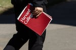 A person holds a Harvard College folder during a tour at Harvard University on April 17 in Cambridge, Mass. 