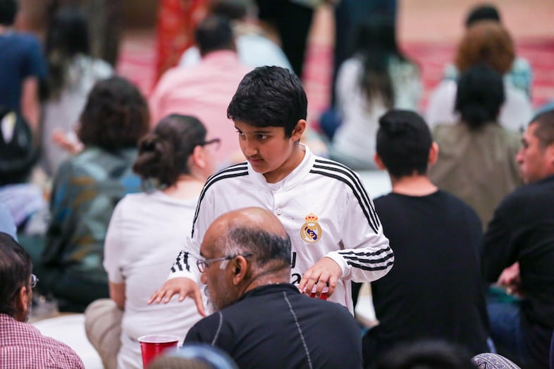 A boy distributes water during the breaking of the fast.