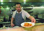 FILE - David Chang presents a dish at Momofuku Noodle Bar in New York on Thursday, Nov. 10, 2011. On Friday, April 12, 2024, Momofuku, a food and restaurant brand started by food mogul Chang, said it won't defend its trademark on the name “chile crunch” after it sparked an outcry by sending cease-and-desist letters to other businesses using the term.