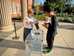 Vice Principal Jessika Magnett helps students with their Yondr cellphone pouches outside Grant High School in Portland on Wednesday, Aug. 28, 2024. It was the first day of school for the entire student body after ninth graders got a jump-start day on Tuesday.