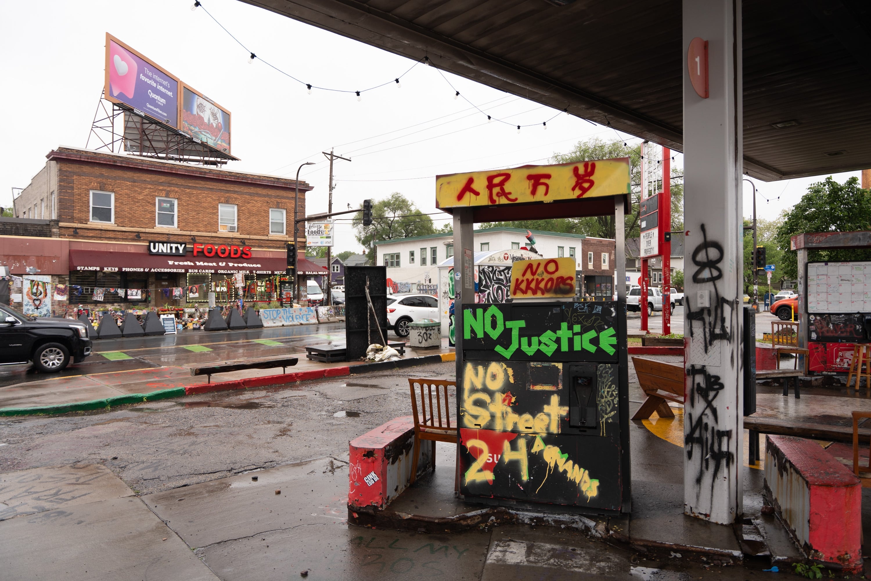 Graffiti condemning the police and demanding racial justice cover defunct gas pumps at George Floyd Square.