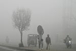 Pedestrians walk along a road engulfed in thick smog in Lahore on November 11, 2024. Lahore, a city of 14 million people stuffed with factories on the border with India, regularly ranks among the world's most polluted cities, but it has hit record levels this month.