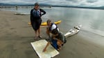 Andrew Emlen, Chris Hathaway and Kyleen Austin study maps on the shore of Lark Island, a sandy dredge spoil east of Tenasillahe Island.