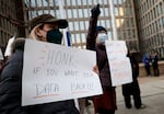 A protester with a sign saying “HONK IF YOU WANT YOUR DATA BACK!!!” stands with other demonstrators outside of the U.S. Office of Personnel Management’s headquarters in February in Washington, D.C., to rally against the DOGE team set up by President Trump’s billionaire adviser Elon Musk getting access to personal data about federal employees.