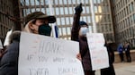 A protester with a sign saying “HONK IF YOU WANT YOUR DATA BACK!!!” stands with other demonstrators outside of the U.S. Office of Personnel Management’s headquarters in February in Washington, D.C., to rally against the DOGE team set up by President Trump’s billionaire adviser Elon Musk getting access to personal data about federal employees.