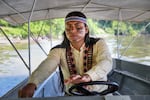 Luciano Peas, a 27-year-old Indigenous boat driver from the village of Sharamentsa, steers one of the solar-powered canoes. The project is run on the ground exclusively by Indigenous people.