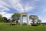 FILE - In this May 17, 2020, file photo, a bird flies from the U.S. into Canada over the Peace Arch in Peace Arch Historical State Park on the border with Canada, where people can walk freely between the two countries at an otherwise closed border, in Blaine, Wash.