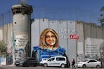 A woman walks past a mural depicting slain Al Jazeera journalist Shireen Abu Akleh, drawn along Israel's separation barrier in the biblical city of Bethlehem in the West Bank, seen in 2022.