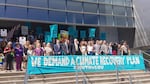 Climate plaintiffs and their attorneys in front of the Eugene Federal Courthouse in summer 2018. A sign in front of the group says "We Demand A Climate Recovery Plan."