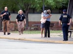 Two people hug outside at Memorial High School where people were evacuated from the scene of a shooting at the Natalie Medical Building on Wednesday, in Tulsa, Okla.