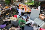 A resident sits beside belongings from their damaged home after a recent landslide triggered by Tropical Storm Trami struck Talisay, Batangas province, Philippines leaving thousands homeless and several villagers dead on Saturday, Oct. 26, 2024.