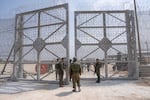 Israeli soldiers gather near a gate to walk through an inspection area for trucks carrying humanitarian aid supplies bound for the Gaza Strip, on the Israeli side of the Erez crossing into northern Gaza, on May 1.