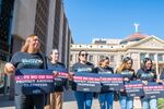 Women hold up signs in opposition to Proposition 314 which would require all police to perform immigration duties in addition their regular enforcement duties in Phoenix, Arizona on Thursday, Oct. 10, 2024.