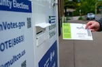 FILE - A voter drops a ballot at the Hillsdale Library in Hillsdale, Ore., in this file photo from May 21, 2024.