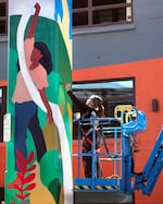 Mural artist Paola De La Cruz paints a column under the Hawthorne Bridge in Portland's Central Eastside in June 2025.