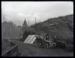 Early automobile stopped on a mountain road.