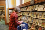 Library Assistant Jeff Burres restocks the shelves in the Multnomah County Central Library's magazines and periodicals section. Parts of the library's vast collection were reorganized during renovations.