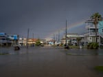 A rainbow appears behind a flooded neighborhood in Jamaica Beach, Texas, on Thursday.