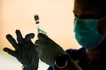 FILE - In this Sept. 14, 2021, file photo, a syringe is prepared with the Pfizer COVID-19 vaccine at a clinic at the Reading Area Community College in Reading, Pa. COVID booster shots have now been cleared for all adult Oregonians.