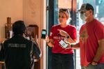 Patrons Naomi and Troy DeMontmorency, from Kern County, Calif., show their digital vaccination certificates to waiter Juan Rodrigues, left, before being allowed to enter the Fred 62 restaurant in the Los Feliz neighborhood of Los Angeles, Monday, Nov. 29, 2021.