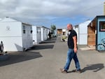 Pastor Gabe Piechowicz in front of a few of the 60 dwellings at Everyone Village in Eugene. Piechowicz used Opportunity Village as a model, which was informed by Portland's Dignity Village.