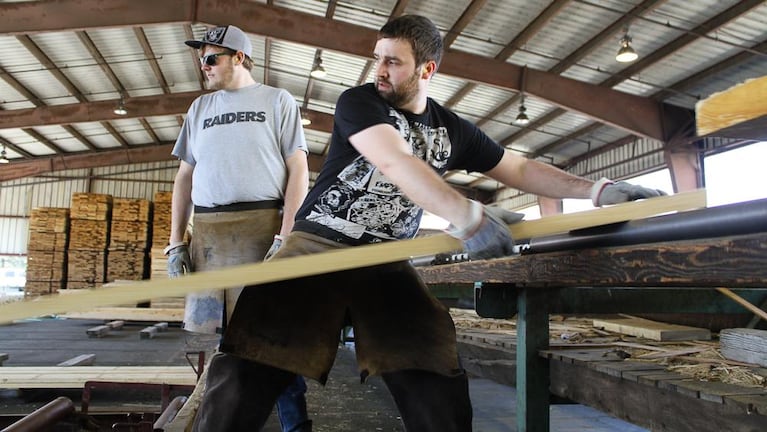 Travis Griess stacks lumber at the Rough and Ready mill, a day after it announced its shut down and laid off most of its workers. 