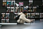 A woman passes a wall covered in photos of hostages held by Hamas on Tuesday, Jan. 30.