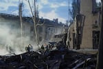 Rescue workers clear the rubble after a Russian ballistic missile attack in Kyiv, Ukraine, on Thursday.