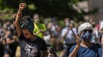 An attendee holds her fist in the air during Rev. E.D. Mondaine’s speech at the NAACP’s Eulogy for Black America held in the wake of the police killing of George Floyd on May 29, 2019, in Portland, Oregon.