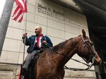 Duane Ehmer rides his horse Hellboy outside Darryl Thorn's sentencing hearing in downtown Portland, Nov. 21, 2017.