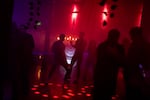 People dance at a Hanukkah rave, the night before the first evening of the Jewish holiday, as a blow-up menorah glows behind them at the Barrel Room in Portland, Ore., on Dec. 13, 2025.