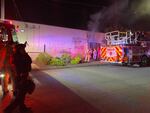 Portland Fire and Rescue firefighters extinguish a blaze at the headquarters of Portland's police officer union on April 13, 2021. The fire was started by police abolition activists.