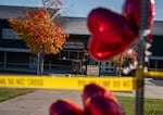 Heart-shaped balloons float among police tape at a makeshift memorial in front of Silver Rail Elementary School in Bend, Ore., on Oct. 16, 2026.