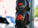 A traffic light alerts bicyclists to wait to cross Southwest Naito Parkway, in Portland, Ore., July 9, 2024. 