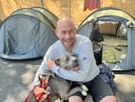 Andrew Lima with his dog Skylar in one of the city's homeless camps on June 11, 2025.