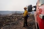 Oregon State Fire Marshall structure protection task force lieutenant Ray Dandeneau keeps a look out as his crew works to protect a home from hot spots burning around it in the Bench Fire off of Highway 26 between Warm Springs and Madras, Ore., on July 28, 2026.
