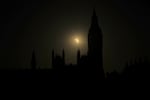 A partial solar eclipse is seen above the Houses of Parliament in London, Wednesday, Aug. 12, 2026.