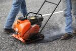 An ODOT maintenance crew uses a machine that tamps down asphalt after filling a pothole on Highway 26.