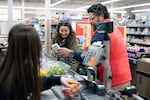 Negro-Henderson and her husband place their groceries on a conveyer belt in a checkout lane at Aldi.