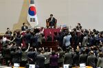 Lawmakers of the ruling People Power Party protest to South Korea's National Assembly Speaker Woo Won Shik, top center, during a plenary session for the impeachment motion against South Korean acting President Han Duck-soo at the National Assembly in Seoul, South Korea, Friday Dec. 27, 2024.