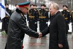 Russian President Vladimir Putin, right, shakes hands with Russian Defense Minister Sergei Shoigu as they arrive to take part in a wreath laying ceremony at the Tomb of the Unknown Soldier in Alexander Garden on Defender of the Fatherland Day, in Moscow, Russia, on Friday.